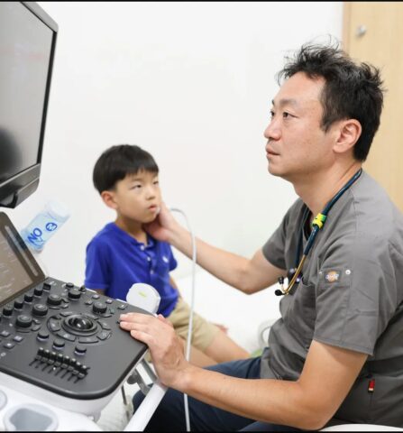 医師がお子さんに腎膀胱エコー検査をする様子