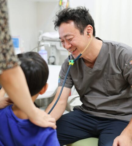 腎・夜尿症外来の担当医 羽田伊知郎が笑顔でお子さんを診察する様子