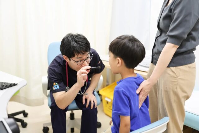 医師がお子さまの顔をのぞき込んで診察する様子