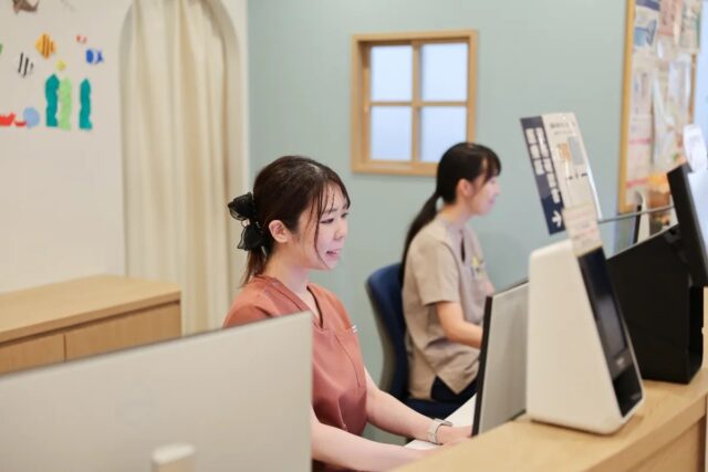 受付で次回の予約をご案内するスタッフの様子